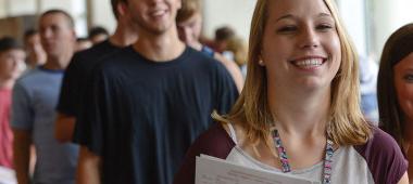 Students smiling at a screen.